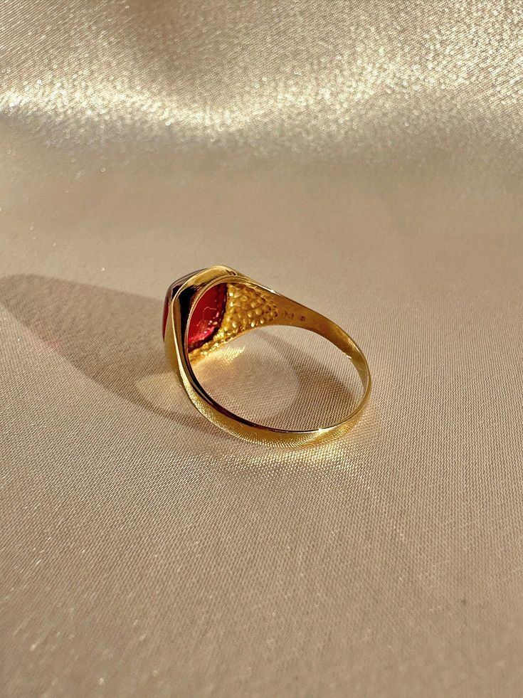 Antique 18k yellow gold ring from the United Kingdom. This signet ring features a vibrant synthetic ruby cabochon. Great antique condition Size: 7.5 resizable* Weight: 3.5 grams Band: 11.1 mm (front), 1.7 mm (back) Synth Ruby: 8.3 mm x 10.0 mm Hallmarks:18CT