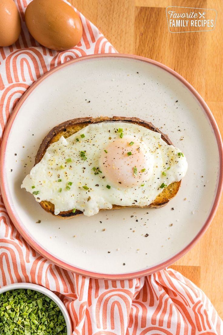 an egg is sitting on top of toasted eggs in a white bowl with green pesto