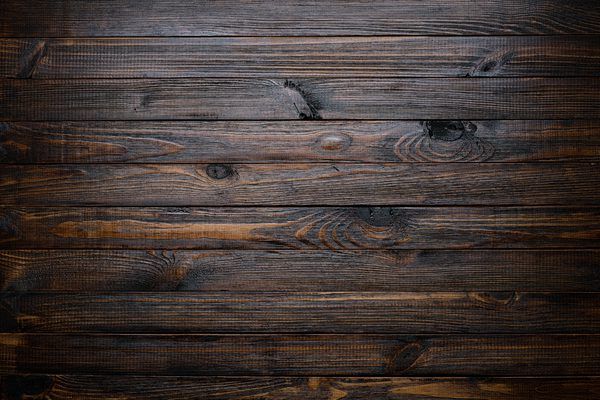 an old wooden background with dark wood grains and knots in the center, as well as horizontal lines