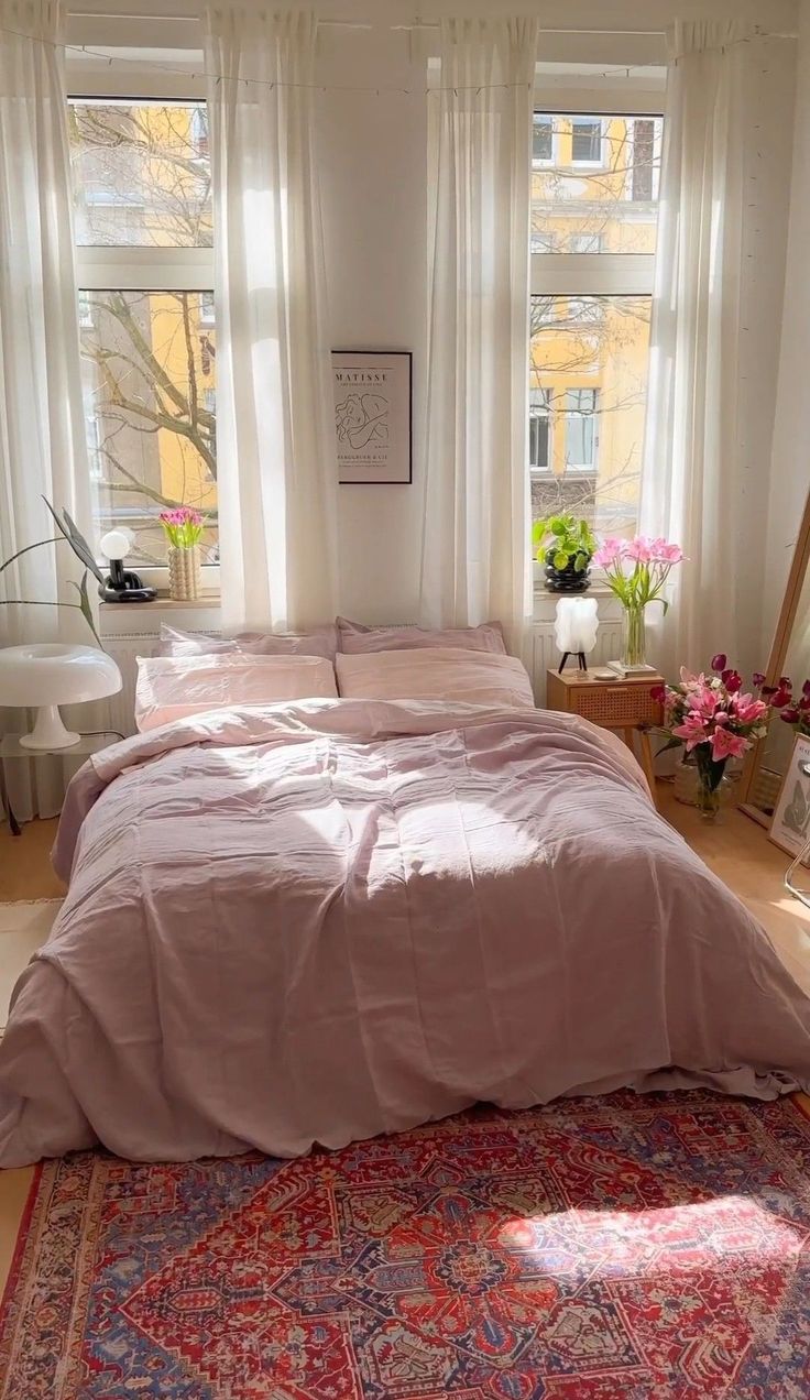 a large bed sitting in a bedroom next to two windows