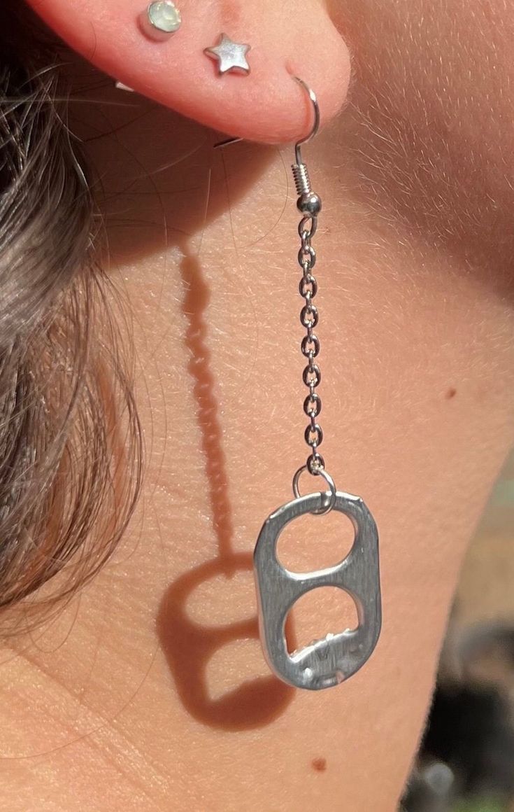 a woman with piercings on her ear and behind the ear is a pair of handcuffs