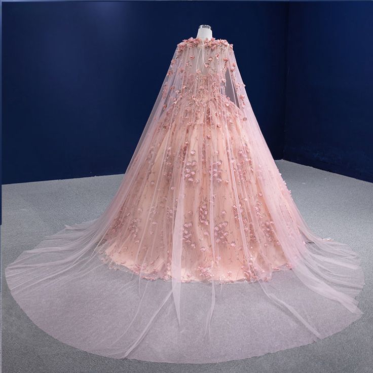 a pink wedding dress on display in a blue room