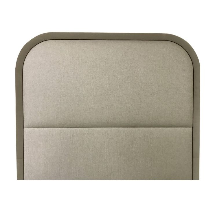 an upholstered headboard with beige linens and grey piping on the sides