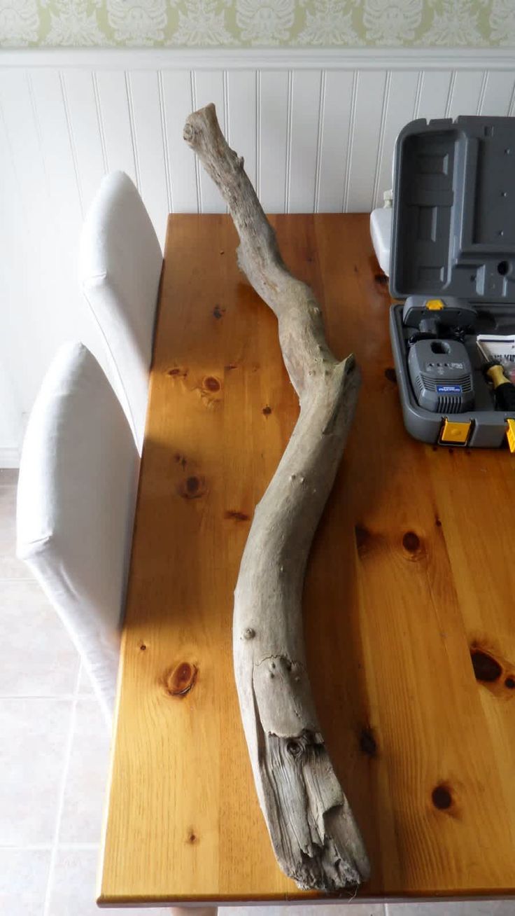 a piece of driftwood sitting on top of a wooden table next to a toolbox