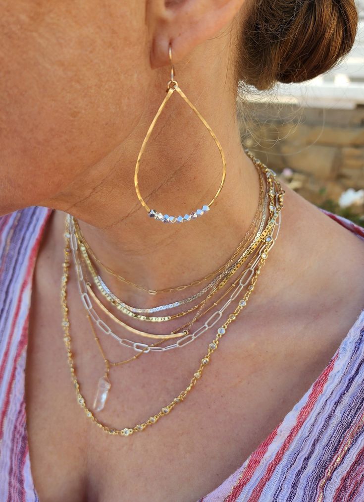 These large teardrop hoop earrings are an interesting twist to the standard. We have added some faceted gold or silver Karen Hill Tribe beads from Thailand in contrasting color for a fun modern mixed metal look! They are handmade from a high quality sterling silver or gold filled wire and hammered to hold their shape and give them shine.  They slide easily onto your ear and are so lightweight you can hardly feel them! They won't weigh on your earlobe. Perfect for everyday!  *Your choice of gold Wire Wrapped Teardrop Hoop Earrings, Dainty Jewelry With Teardrop Dangling Beads, Dainty Teardrop Wire Wrapped Hoop Earrings, Dainty Teardrop Jewelry With Dangling Beads, Everyday Teardrop Earrings With Dangling Beads, Everyday Teardrop Jewelry With Dangling Beads, Silver Earrings Hoops, Gold And Silver Earrings, Tiny Necklace