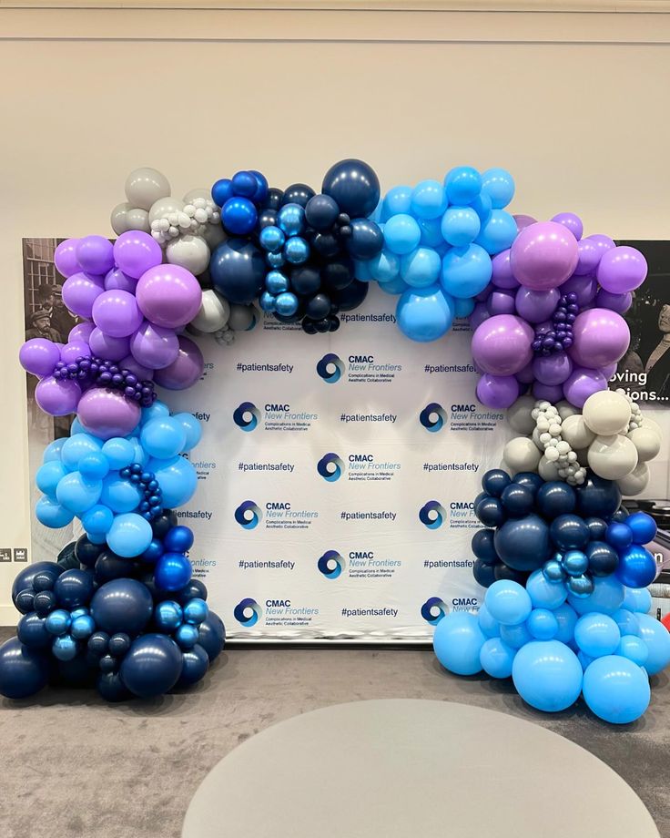 balloons are arranged in the shape of an arch for a balloon display at a corporate event