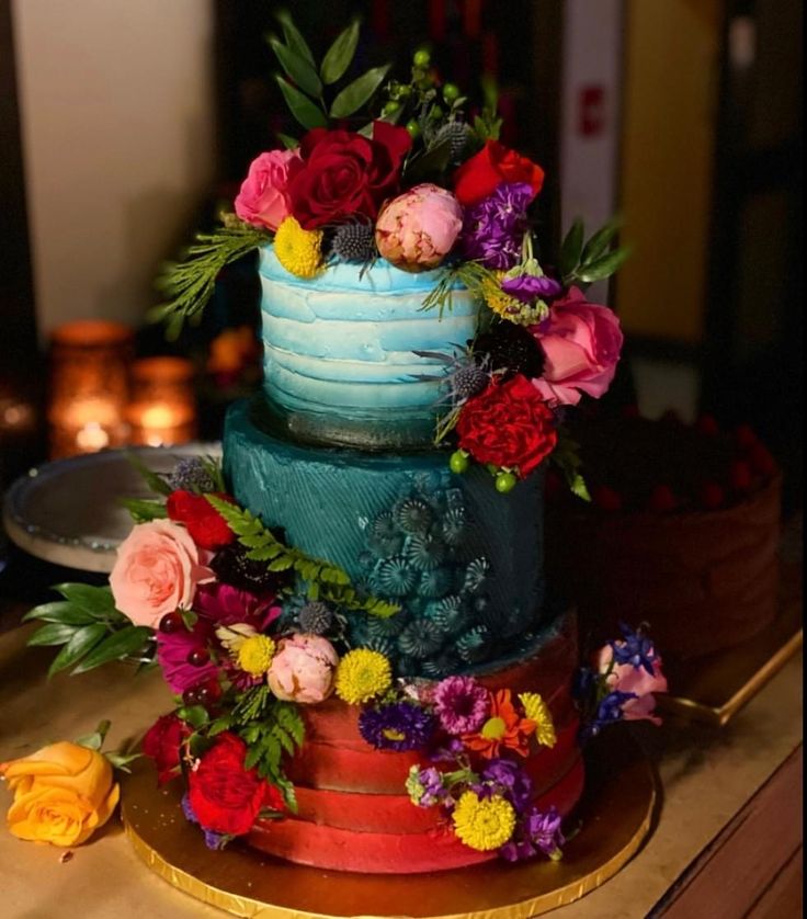 there is a multi layer cake with flowers on it