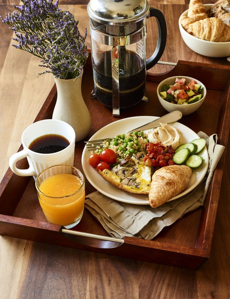 a wooden tray topped with food and drinks