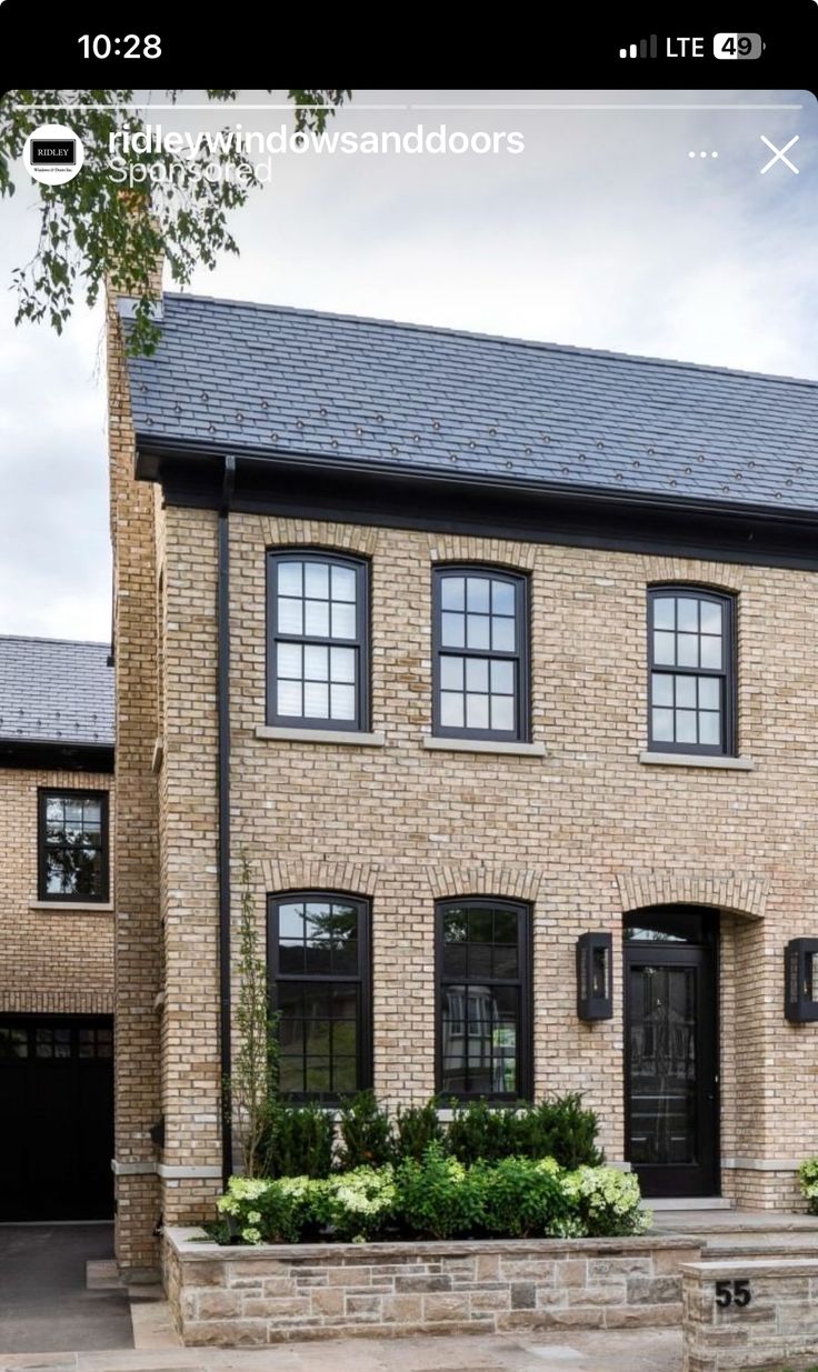 a large brick house with black doors and windows