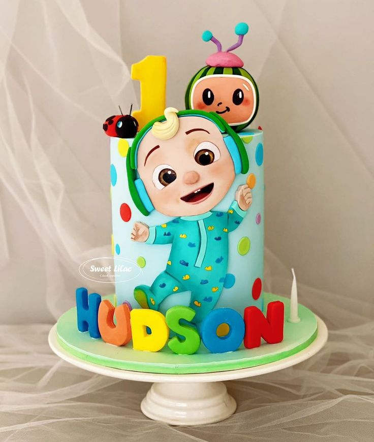 a birthday cake with the number one on it and two children's faces in clown costumes