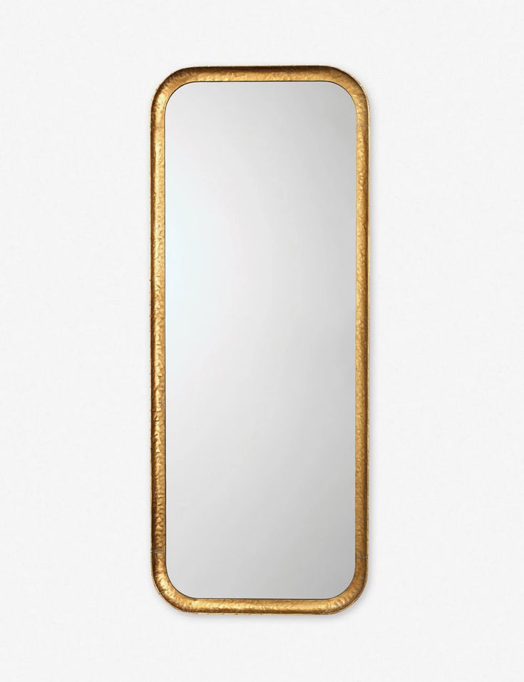 a gold framed mirror against a white wall