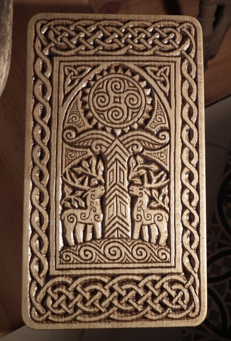 an intricately carved wooden plaque with two people in the center, surrounded by celtic designs