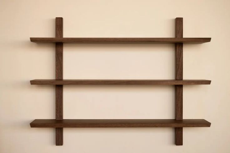 three wooden shelves on the wall, one with two ends and one with no end