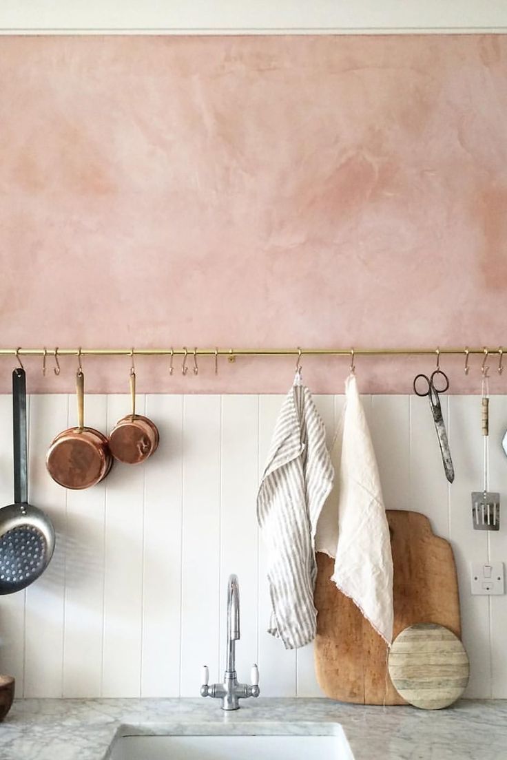 a kitchen counter with pots and pans hanging on the wall