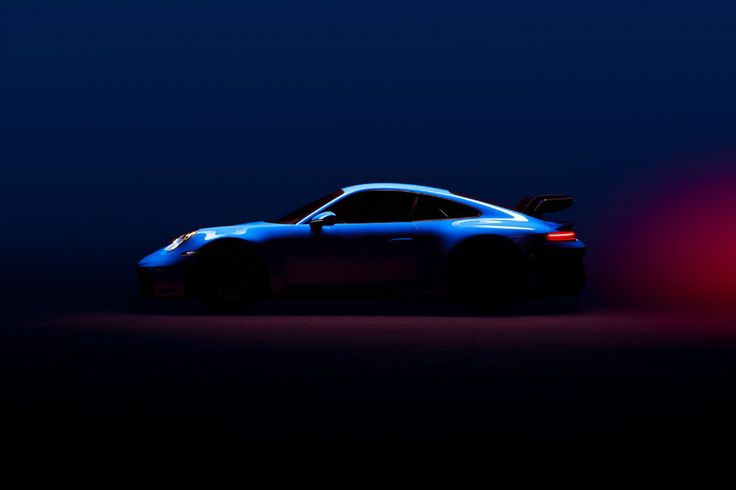 a blue sports car in the dark with red lights on it's taillights