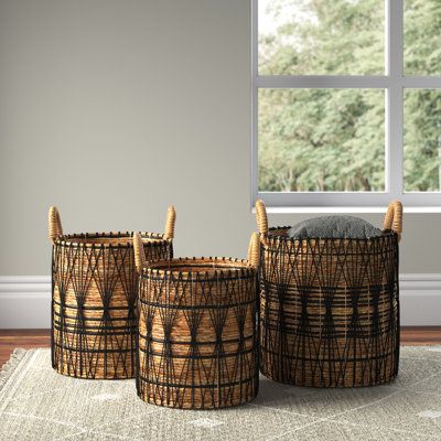 three baskets sitting on top of a rug next to a window