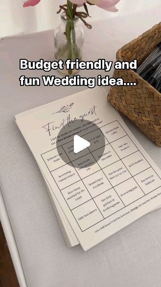 a table topped with a vase filled with flowers next to a card board and pen