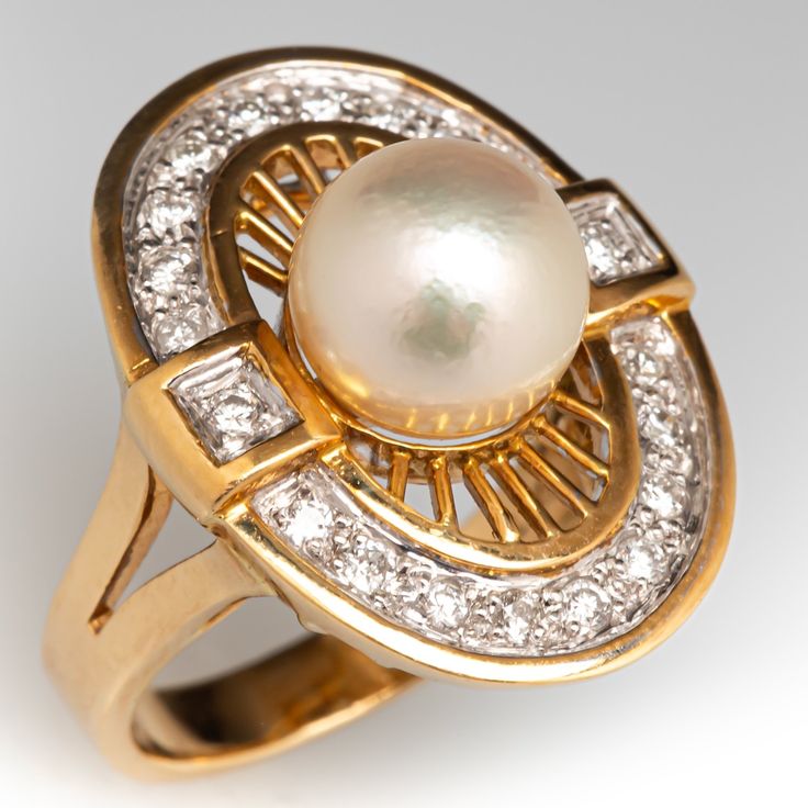 This radiant ring features an oval shaped gallery accented with one (1)  saltwater Akoya pearl, and a halo of twenty (20) bead set round brilliant cut diamond accents. The ring measures 21.6mm at the top, rises 10.7mm above the finger, tapering to 3.0mm wide and 1.0mm thick at the base of the shank.   It is crafted in 18k yellow gold and is currently a size 4.75.  The ring matches perfectly with the earrings under sku ab73326. Oval Diamond Pearl Ring For Formal Occasions, Oval Diamond White Pearl Ring, Oval Diamond White Pearl Ring With Diamond, Diamond White Oval Pearl Ring For Anniversary, Oval Diamond Pearl Ring In Diamond White, Formal Oval Pearl Ring With Brilliant Cut, Oval Pearl Ring With Diamond Accents, Oval Brilliant Cut Pearl Ring For Formal Occasions, Formal Akoya Pearl Oval Rings