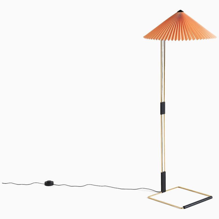 an orange floor lamp with a black base and a white light on the top, in front of a white background