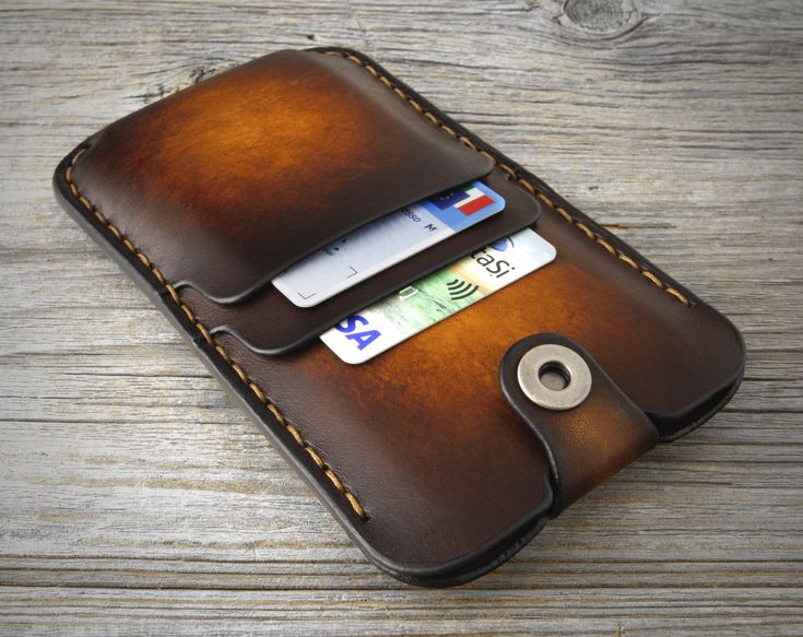 a leather wallet with credit cards in it on a wooden table, close up view