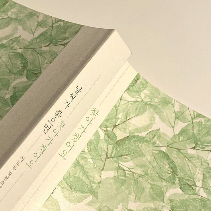 an open book with green leaves on it