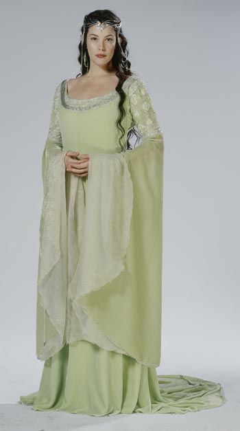 a woman in a green dress with a white shawl on her head and shoulders