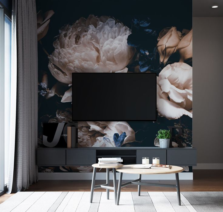 a living room scene with focus on the television and large flower wall mural behind it