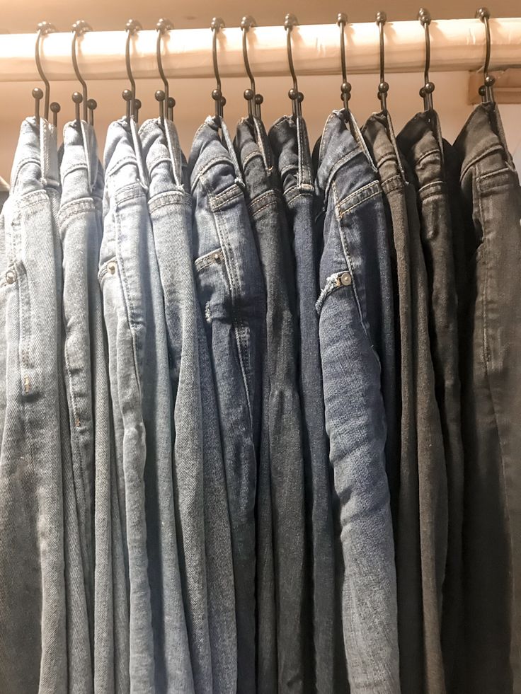 several pairs of jeans hanging on a rail