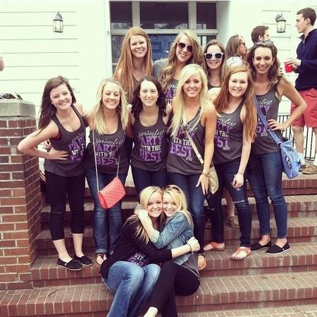 a group of young women posing for a photo on the steps in front of a house