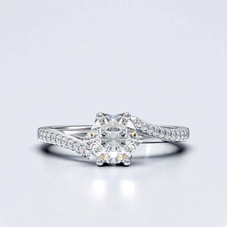 a white gold ring with an oval cut diamond on the side and pave set shoulders