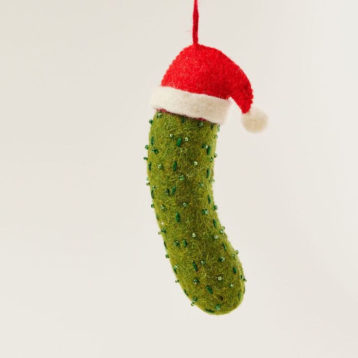 a green christmas ornament with a santa hat on it