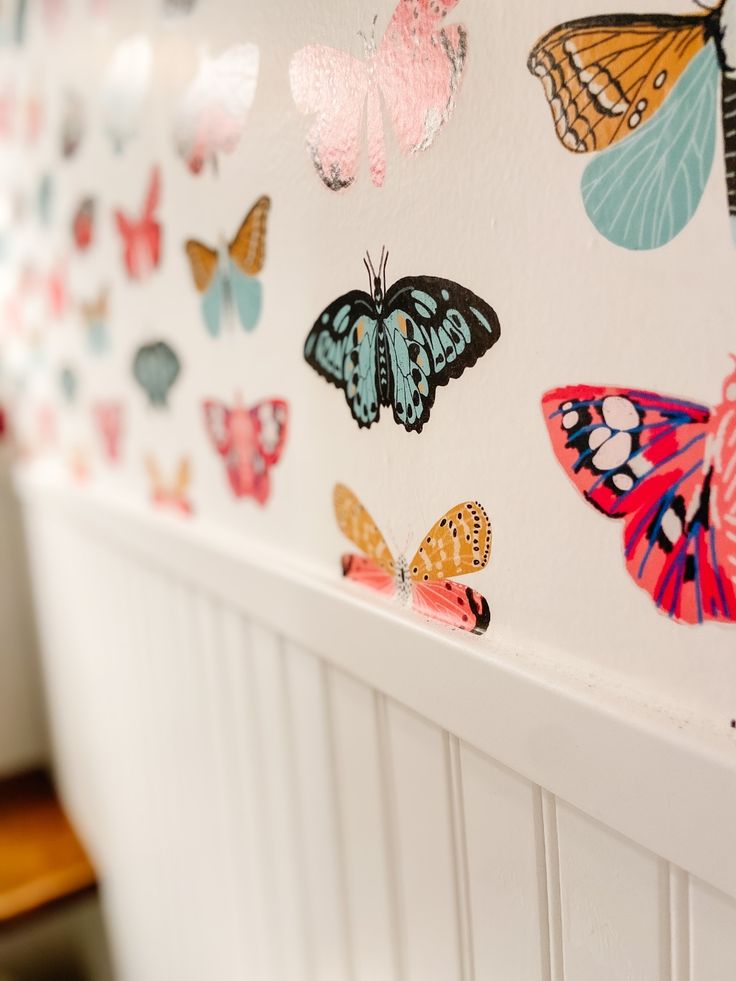 colorful butterflies painted on the side of a white wall