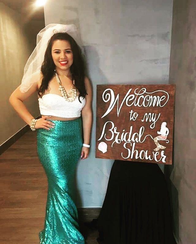 a woman standing next to a sign that says welcome to my bridal shower