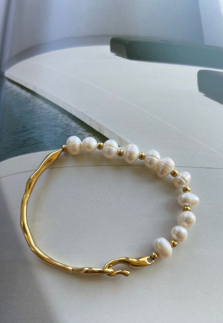 Giselle is a stunning bracelet made with natural fresh water pearls. Combining classic beauty with understated luxury, this bracelet is perfect for any occasion. Its waterproof and non-tarnish properties make it a durable and practical choice for any occasion. Enjoy the beauty without worrying about allergies or damage. Main material: pearl natural freshwater, gold plating, stainless steel, baroque pearl.Bracelet diameter: 5,2 cm.Bracelet width: 0,7 cm Mass: 9 Pearl Chain Bangle Bracelets, Pearl Bangle Bracelet With Pearl Chain, Luxury Yellow Gold Pearl Bracelet Gift, Pearl Chain Bracelet As Gift, Baroque Pearl Bracelets For Wedding, Everyday Beaded Bracelets With Pearl Drop, Everyday Pearl Bracelets With Pearl Drop, Everyday Pearl White Bracelet With Pearl Chain, Pearl White Everyday Bracelet With Pearl Chain