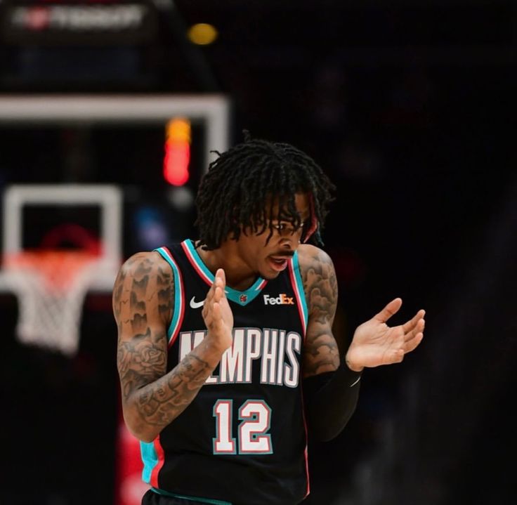 a basketball player with dreadlocks on his head and hands out in front of him