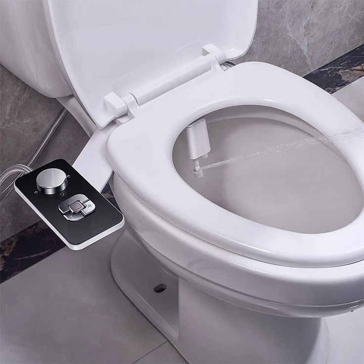 a toilet with the lid up and an appliance attached to it