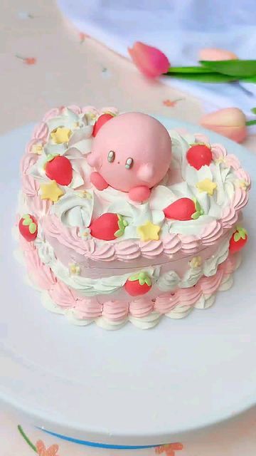 a pink cake decorated with an infant's head in the center and flowers around it