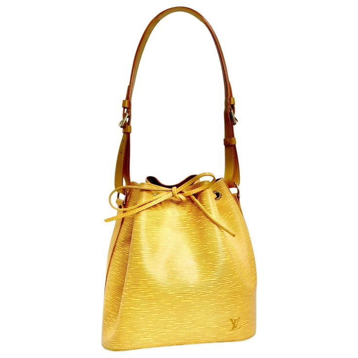 Introducing a timeless classic: the Louis Vuitton Epi Petite Noe Shoulder Bag. Crafted in the iconic textured Epi leather, this bag showcases a vibrant and sunny yellow hue that exudes elegance and style. The bucket-style drawstring design adds a touch of chic sophistication, and the smooth leather cinch cord with gold eyelets enhances the bag's allure. An adjustable smooth leather shoulder strap featuring gold buckles allows for customizable wear, ensuring comfort while making a statement. Open Sunny Yellow, Vintage Louis Vuitton, Roberto Cavalli, Timeless Classic, Fashion Handbags, Smooth Leather, Christian Dior, Kitten Heels, Violet