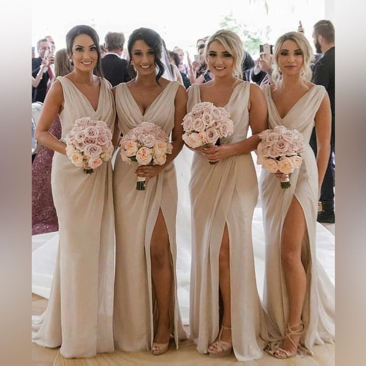 the bridesmaids are all dressed in beige dresses and holding their bouquets together