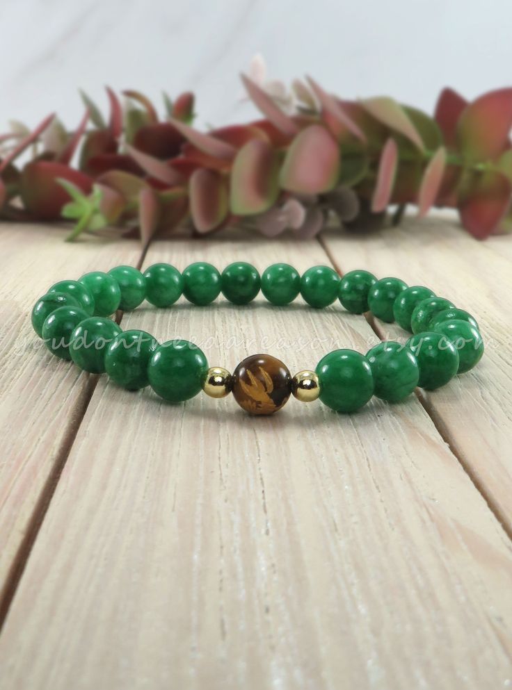 Green jade stretch gemstone bracelet with a gorgeous carved tiger eye focal bead D E T A I L S * 8mm green jade beads * 8mm carved tiger eye bead * Synthetic hematite spacer beads * .7mm stretch cord S I Z I N G * Please measure around your wrist by using a flexible tape measure (or a string and a ruler to line it up to). * Depending on how snug or loose you wear your bracelets, add up to 0.5" to get your desired size.  * I measure all of my bracelets by the inner circumference of the bracelet a Tiger Eye Bracelet, Tiger Eye Beads, Handmade Jewelry Designs, Handmade Jewelry Gift, Jade Bracelet, Eye Bracelet, Fall Jewelry, Elastic Bracelet, Zipper Bag