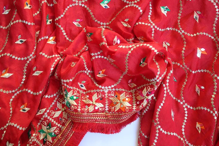 Phulkari refers to the folk embroidery of the Punjab. Although phulkari means floral work, the design include not only flowers but also covers motifs and geometrical shapes. The craft of phulkari has undergone changes over the centuries. This gorgeous colorful phulkari on pure chinnon in red color is so versatile and can be worn as a dupata, scarf or on any wedding occasion. Our phulkaris are handcrafted to perfection keeping in mind the authenticity of the culture in an urban way. Stand out wit Jamawar Traditional Wear With Multicolor Embroidery For Festivals, Red Festival Saree With Motifs, Red Bohemian Embroidered Fabric In Traditional Drape, Red Festival Dupatta With Motifs, Red Bohemian Embroidered Fabric With Traditional Drape, Red Chikankari Embroidered Fabric For Navratri, Traditional Wear With Patterns For Navratri, Traditional Wear With Patterns For Navratri Festival, Traditional Wear With Festive Patterns For Navratri