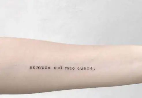 a person with a tattoo on their arm that says sempre ne mio cuee