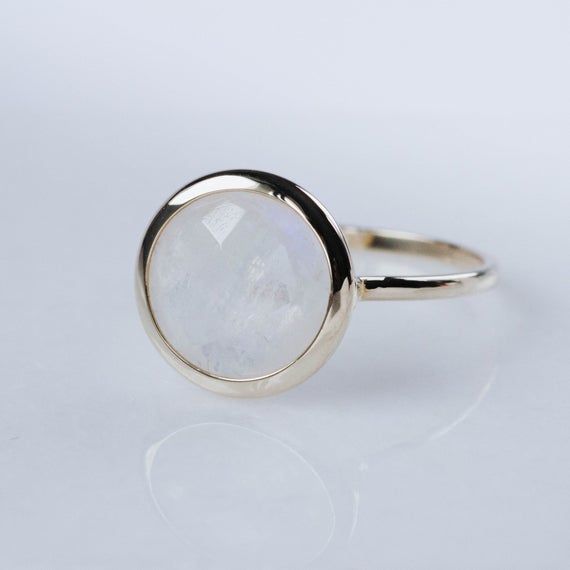 14K gold rainbow moonstone ring. A gorgeous moonstone ring, ideal for every woman who loves elegant style. An excellent choice for anniversary gift for her or birthday gift or Mothers Day Gift. The gemstone is natural and conflict-free mined.  100% handcrafted with love!PRODUCT DETAILS● Material: 14K solid gold, white gold, rose gold● Gemstone: Moonstone, briolette cut● Stone Diameter: 8mm (0.3in) or 10mm (0.4in) RING SIZING For General Reference:● we use standard US Ring Sizing● an average wome Everyday 14k Gold Moonstone Birthstone Ring, Elegant Moonstone Ring With Bezel Setting, White Moonstone Ring With Si Clarity, Modern Moonstone Rings For Gifting, Delicate 14k Gold Moonstone Ring, Modern Moonstone Rings For Gifts, Modern Moonstone Rings As Gift, Elegant Gold Moonstone Ring With Natural Stones, Elegant Round Moonstone Ring For Gift