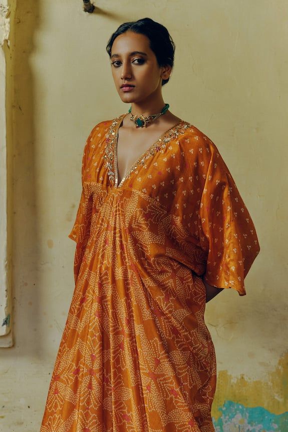 Ochre orange kaftan with all over bandhani blossom print, floral aari, sequins, gota, dori, anchor and zardozi hand embroidered highlights on the plunging V neckline and cascading cowl drapes on the sides. - Aza Fashions Orange Kaftan, Kaftan Pattern, Kaftan For Women, Printed Kaftan, Mixed Prints, Blossom Print, Luxury Sale, Dupion Silk, Embroidered Neckline