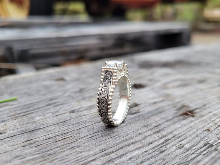 two silver rings sitting on top of a wooden table