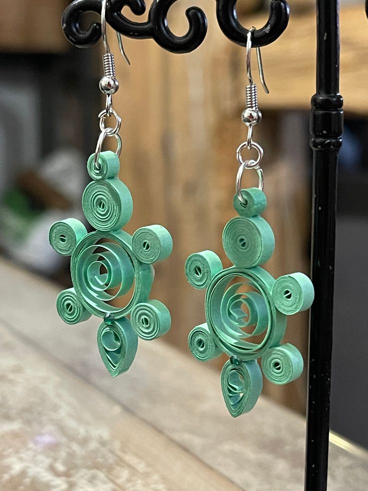 the earrings are made out of green paper and have spirals on each earring