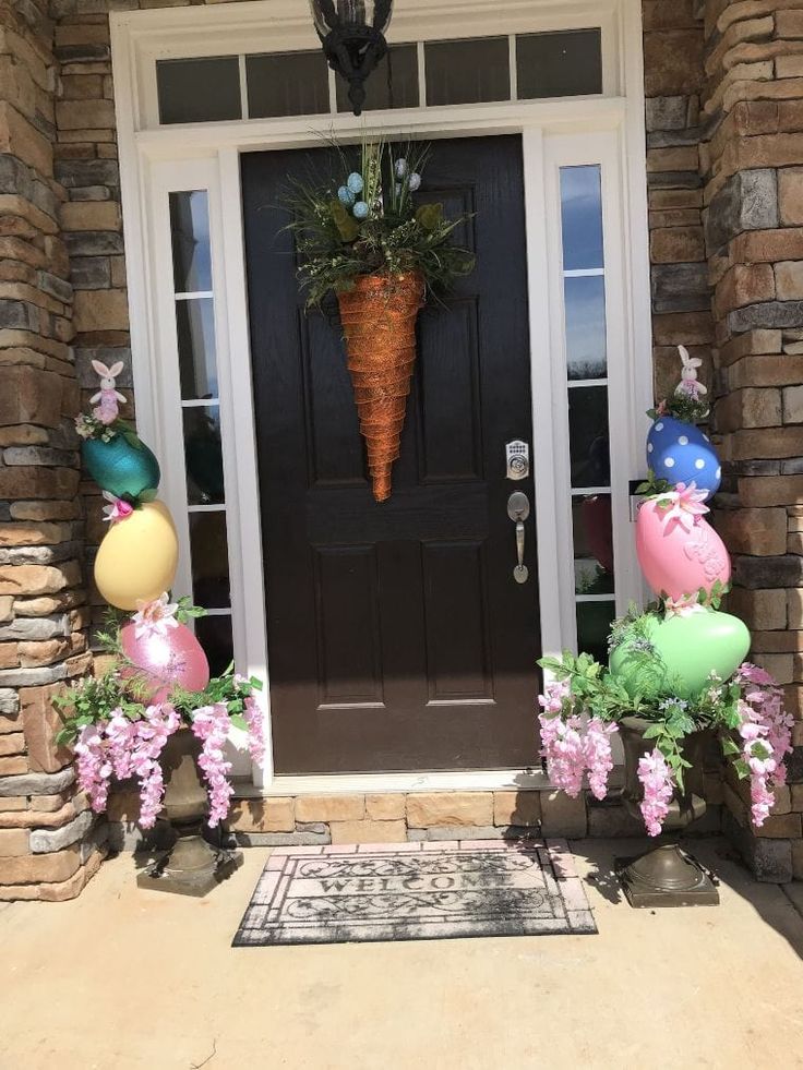 a front door decorated for easter with balloons and flowers on the side walk next to it