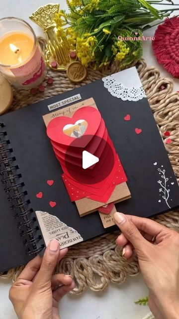 someone is making a valentine card out of paper and glue on the inside of a book