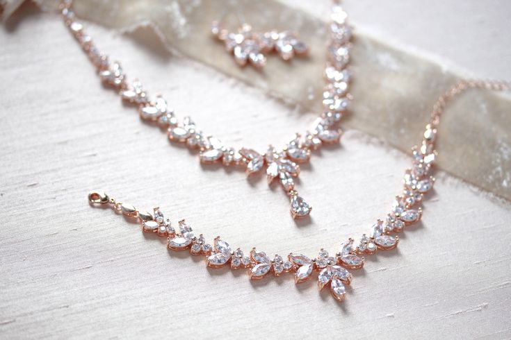 "The classic design of this radiant rose gold bridal necklace set is perfect for brides who truly want to shine! - Necklace measures 16\" - Earrings measure 1\" - Bracelet measures 6\" and extends to 8 inches - Handcrafted with high quality cubic zirconia - Available in rose gold, yellow gold and rhodium (silver) finish Browse My Entire Shop For More Jewelry & Accessories: https://www.etsy.com/shop/TheExquisiteBride Browse My Shop For Earrings: https://www.etsy.com/shop/TheExquisiteBride?sec Elegant Rose Gold Jewelry For Mother Of The Bride, Rose Gold Delicate Bridal Necklace For Formal Occasions, Delicate Rose Gold Bridal Necklace For Formal Occasions, Formal Bridal Necklace In Rose Gold With Elegant Design, Elegant Rose Gold Jewelry Sets For Formal Occasions, Formal Rose Gold Jewelry Sets With Elegant Design, Formal Rose Gold Elegant Jewelry Sets, Formal Elegant Rose Gold Jewelry Sets, Pink Gold Cubic Zirconia Necklace For Wedding