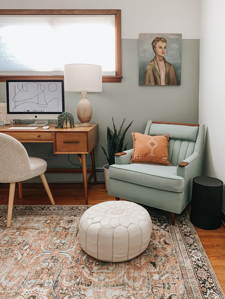 a living room with a chair, ottoman and rug on the floor next to a window